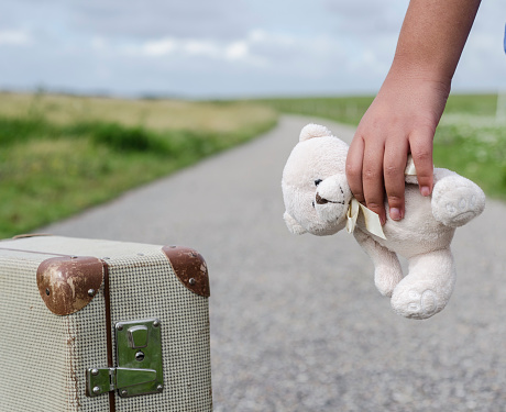Girl goes with her teddybear on the road