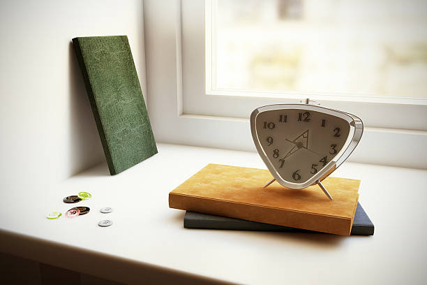 Books alarm clock and buttons on the window sill