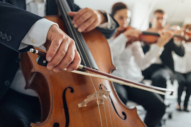 Cello player's hands close up Professional cello player's hands close up, he is performing with string section of the symphony orchestra symphony orchestra photos stock pictures, royalty-free photos & images