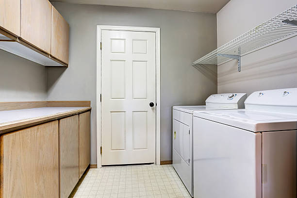 istock Laundry room with washer and dryer with tile floor. 591994994