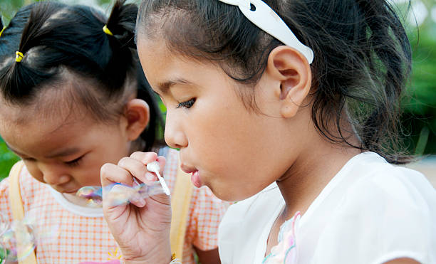 istock Little Girls Blowing Bubbles 591995700