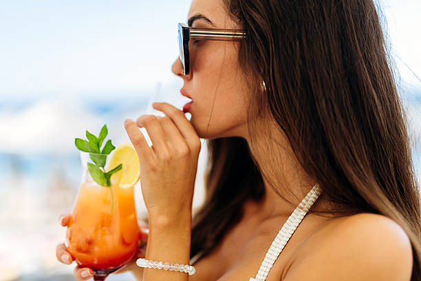 istock Beautiful woman drinking cocktail 591995936
