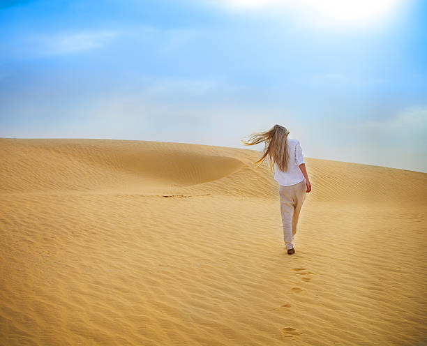 Beauty blond woman walking in Sahara desert. Tunisia. Beauty blond woman walking in desert. Sahara desert - Douz, Tunisia. tunisia sahara douz stock pictures, royalty-free photos & images