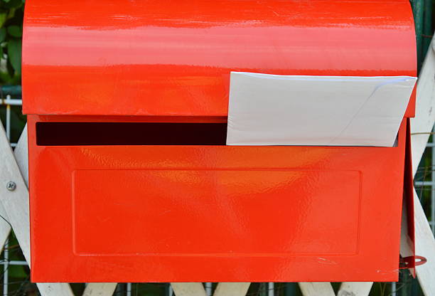 istock white envelope in red post box on home fence 591998284