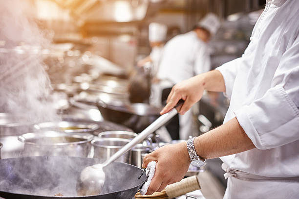 chefe de cozinha em cozinha de restaurante no fogão com recipiente - cooking process imagens e fotografias de stock