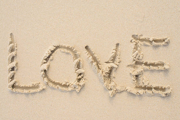 istock Love message written in sand. Beach background. 591998840
