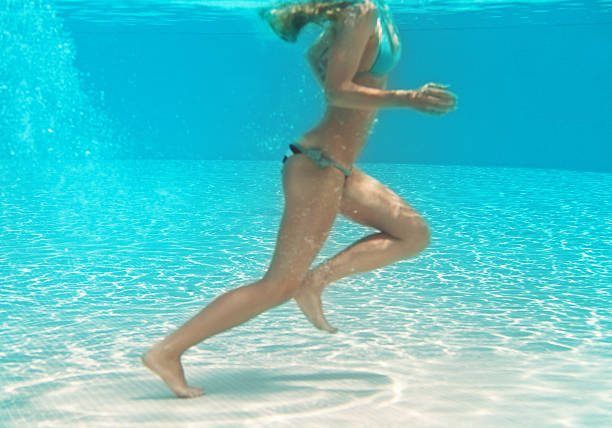 Young sporty woman running underwater. Fitness concept