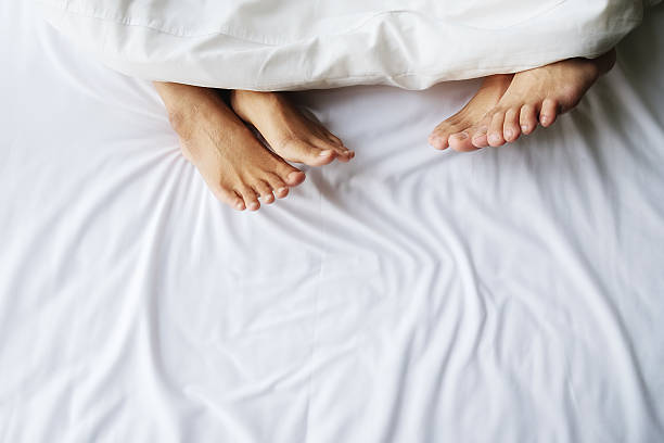 istock Feet of couple in comfortable bed. 592001116