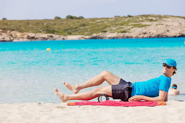 A male guy, doing some exercises with a black roll at the beach. XXXL size image. Image taken with Canon EOS 5Ds and EF 70-200mm USM L 2,8. 