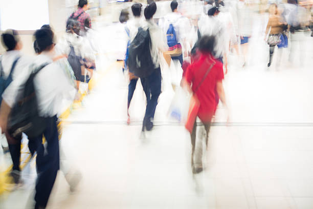 Close-up of a group of people/students walking fast indoors, Kyoto, Japan. Unrecognizable people, brightly lit, copy space. Nikon D800, full frame, XXXL. iStockalypse Kyoto 2016.