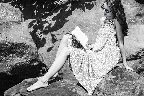 istock girl sit on rock reading book 592007894