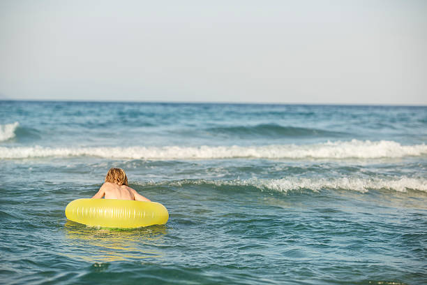 istock Boy in inflatable ring having fun, swimming 592015088