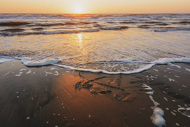 istock Figure heart pierced by an arrow drawn on the sandy 592015410
