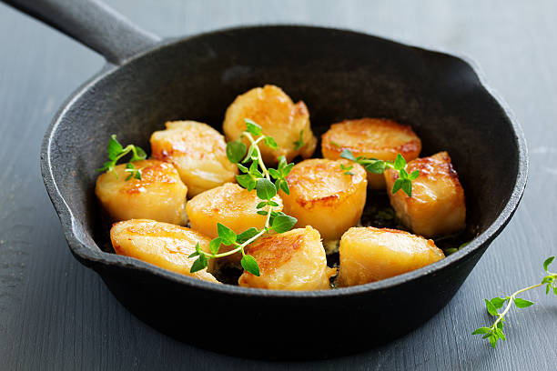 istock Scallops fried in cream sauce with herbs. 592018416