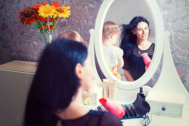 istock Mother and daughter sitting at dressing table at house. 592018452