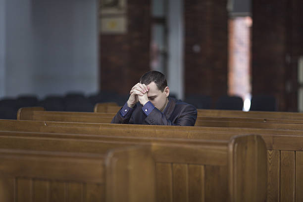 istock Man praying in church 592018894