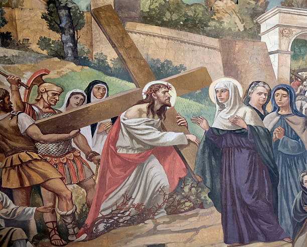 Jesus Christ and virgin Mary bronze statue. On background the cross. It can be used for events, concepts and backgrounds.