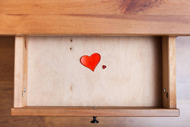 two red glass hearts in open drawer