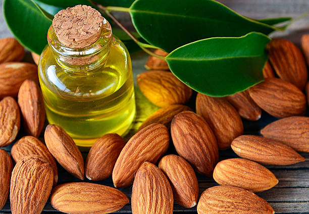 Almonds seed and almond oil on old wooden background.. stock photo