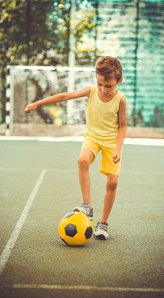 istock Boy with  football ball on stadium 592025688