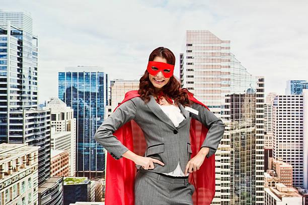 istock Smiling superhero standing in front of city 592026430