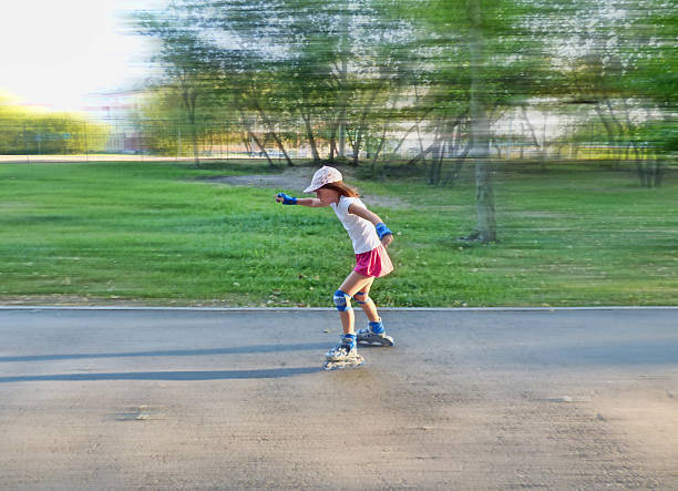 istock Little girl roller skate in park. With a motion blur. 592028990