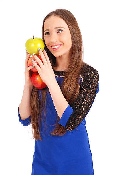 giovane sorridente ragazza con tre mele brunette  - healthy eating green studio shot vertical foto e immagini stock