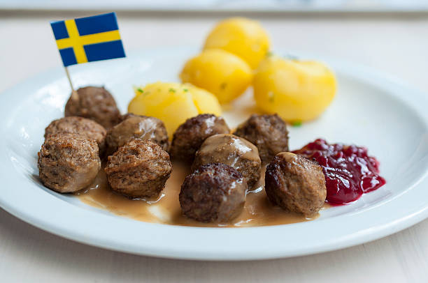 Meatballs with boiled potatoes and sweet red sauce Meatballs with boiled potatoes and sweet red sauce decorated by Swedish flag - traditional Swedish dish sweden stock pictures, royalty-free photos & images