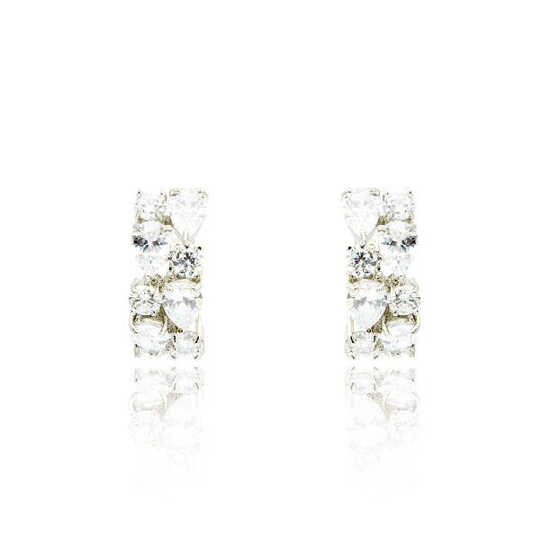 istock Pair of silver diamond earrings isolated on white 592033982