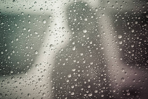 istock Rain drop at surface of a car. Water drop background. 592033998