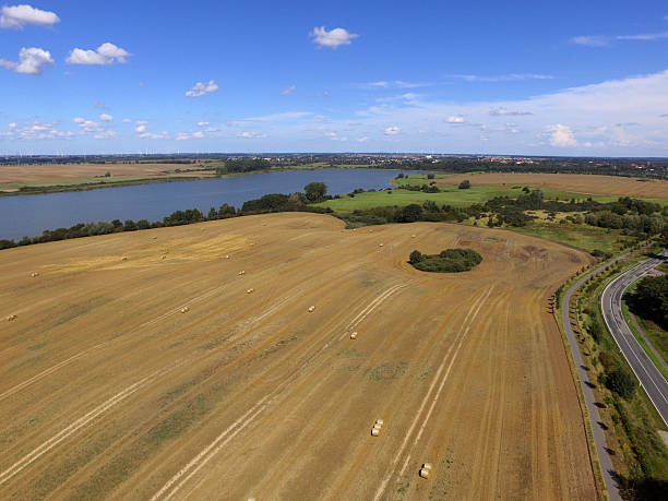 istock aerial view  of golden fields with lake and blue sky 592034412