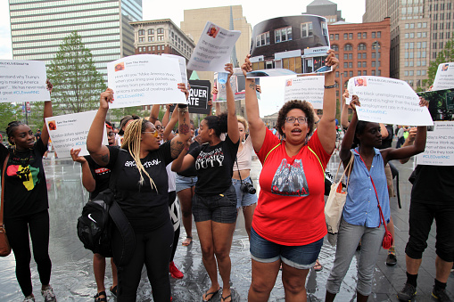 Cleveland, Ohio, USA - July 21, 2016:  A group of Black Lives Matter demonstrators stand in the flooded center of the Public Square on the fourth and last afternoon of the Republican National Convention.  As evening approached, the action in the square became smaller in scale and more personal.