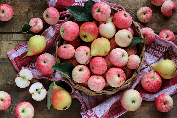 istock Ripe apples and pears on a wooden platform, top view. 592034824