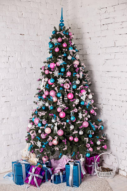 Decorated Christmas tree on white background Decorated Christmas tree on white background with blue, silver and pink decorations, snowflakes ang gifts. Cold colors. Studio vertical colorful photo pink christmas tree stock pictures, royalty-free photos & images