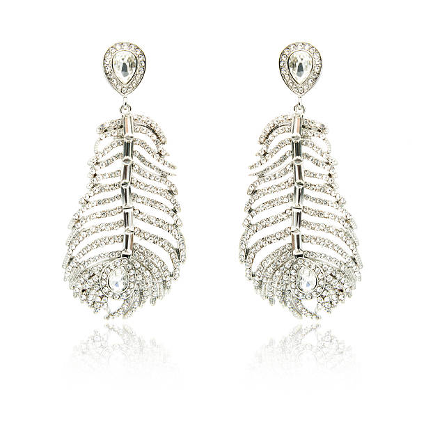 istock Pair of silver diamond earrings isolated on white 592036624