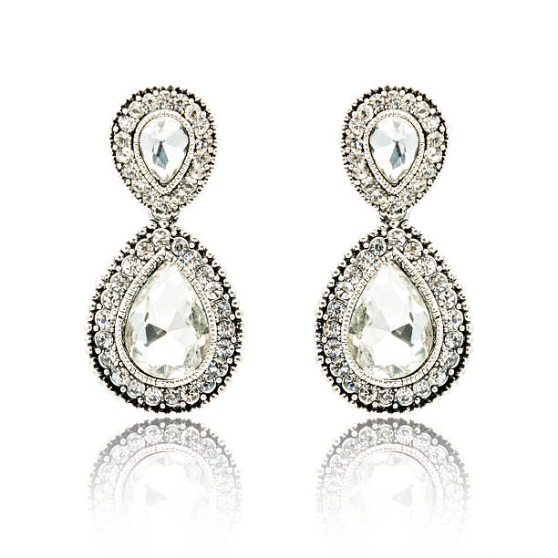 istock Pair of silver diamond earrings isolated on white 592357968