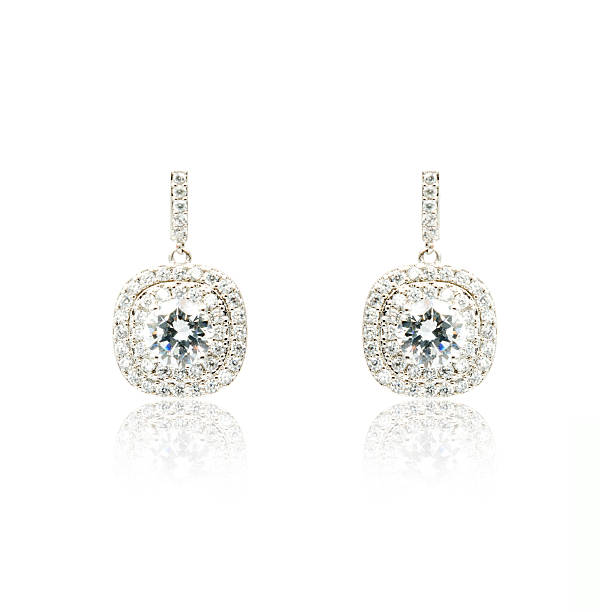 istock Pair of silver diamond earrings isolated on white 592358220