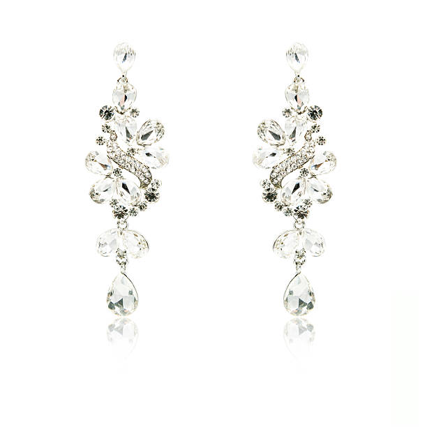 istock Pair of silver diamond earrings isolated on white 592358440