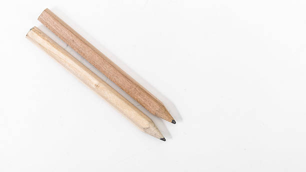 istock Two wooden pencils in a row on a white background 592358556