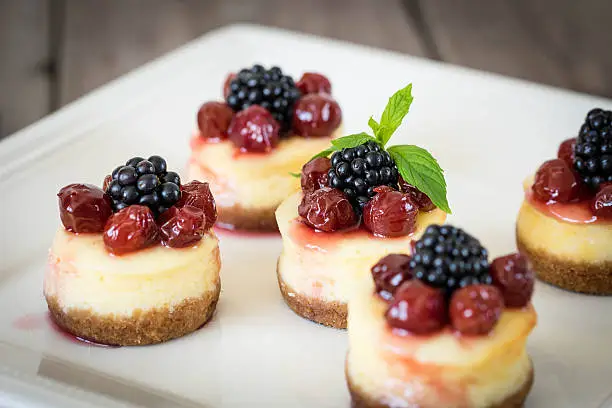 Mini cheesecake with cherry and blackberry on a plate for your design