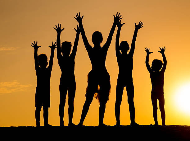 istock silhouette of kids against sunset 592363974