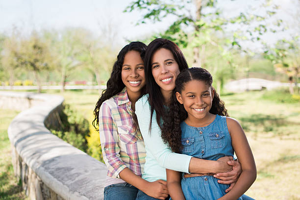 istock Mother and daughters smiling at the camera 592366528