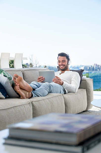 istock Man lying on the sofa with headphones. 592367366