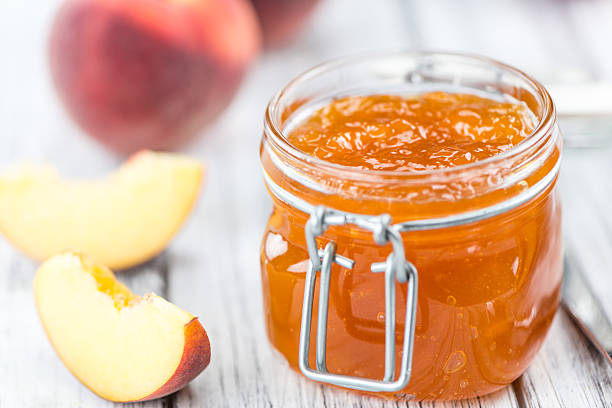 peach jam (mise au point sélective) - gelatin dessert orange fruit marmalade photos et images de collection