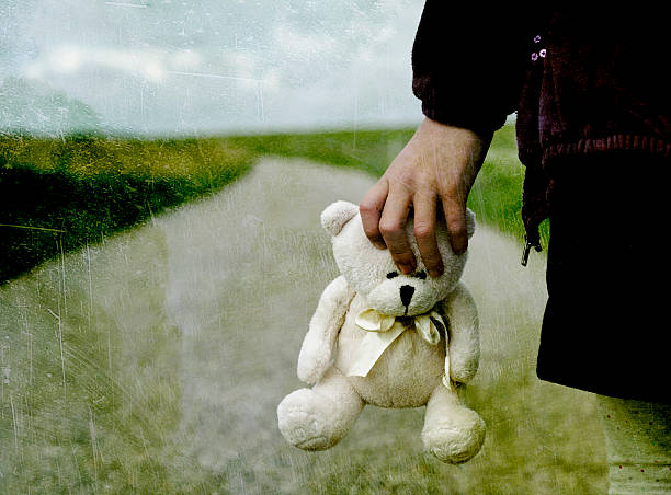 Refugee child goes on the road with her teddy bear
