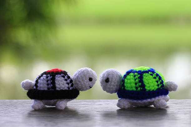 istock Handmade crochet doll turtle on green background. 592380148