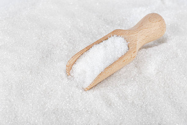 istock Wooden scoop on white sugar 592383626