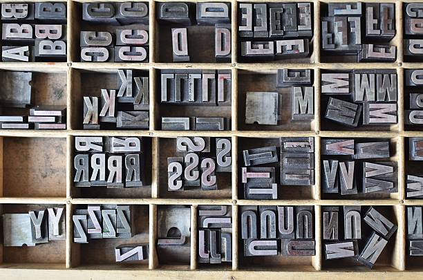 Letterpress letters in a wooden box Overhead view of metallic letters in a wooden box, used for letterpress printing on a manual print machine typesetter stock pictures, royalty-free photos & images