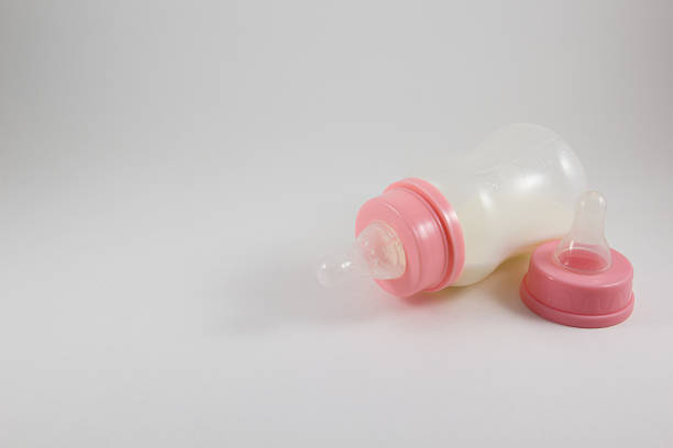 istock Baby bottle with milk and pacifier on a white background 592386508