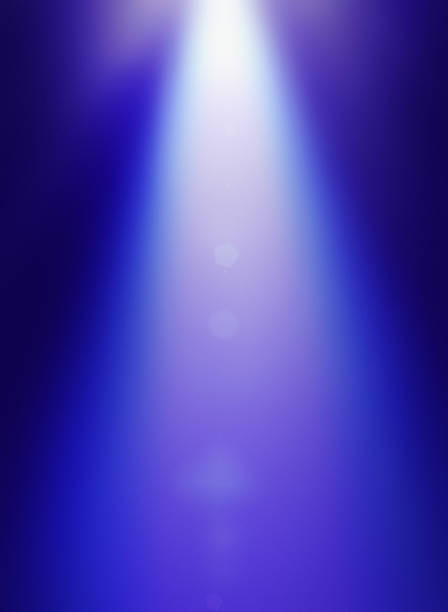 istock Beam of soft white light descending from deep blue background 592388006